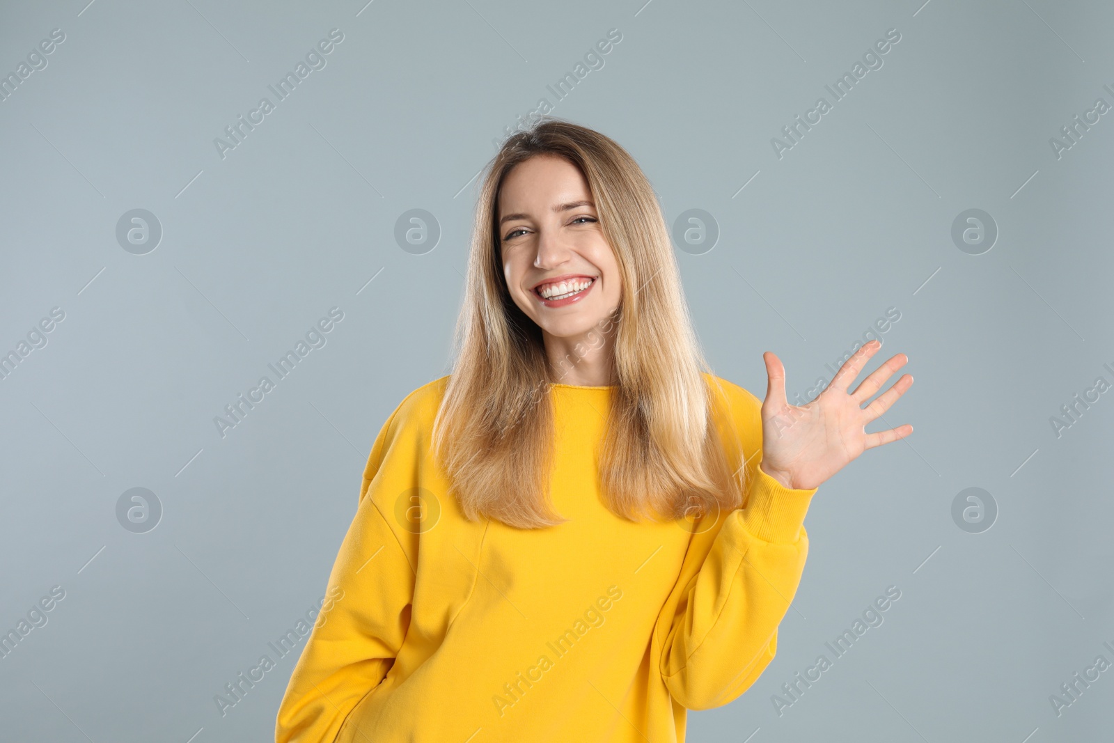 Photo of Woman showing number five with her hand on light grey background