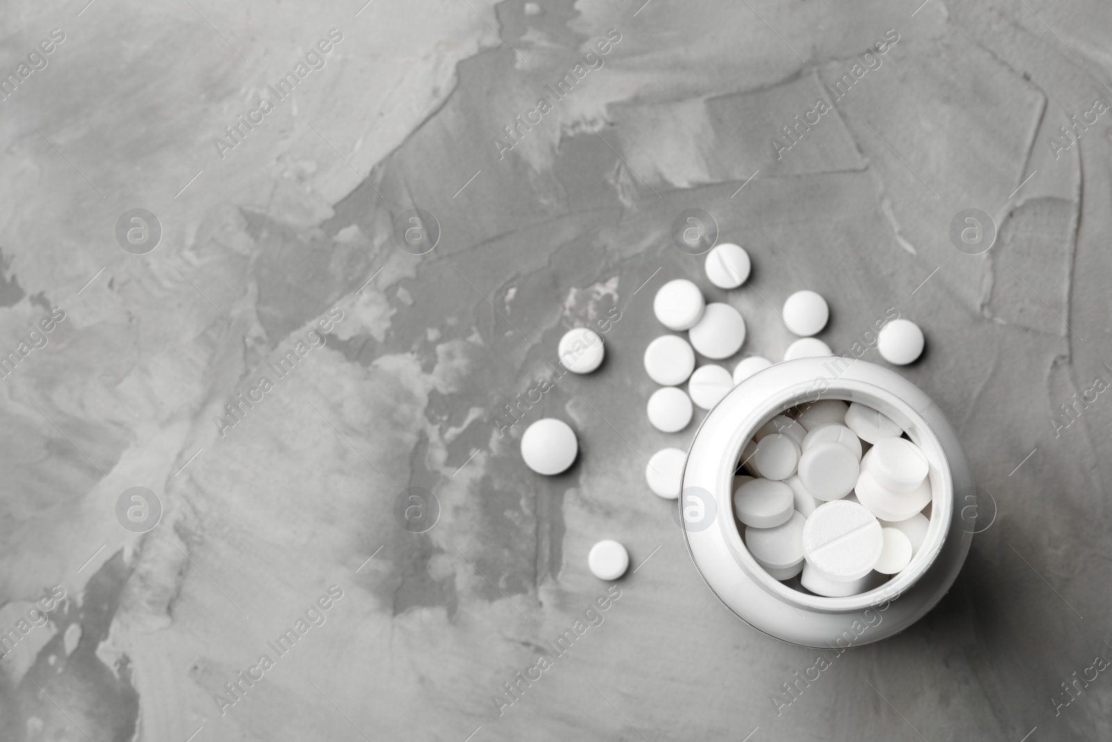 Photo of Bottle with different pills on table, flat lay. Space for text