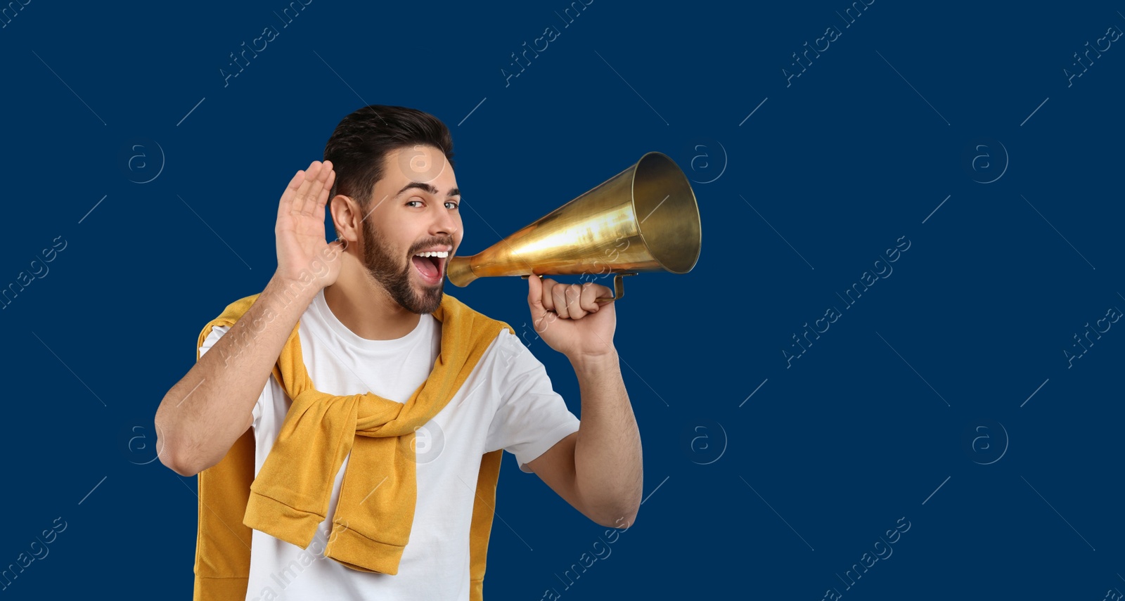Photo of Young man with megaphone on blue background