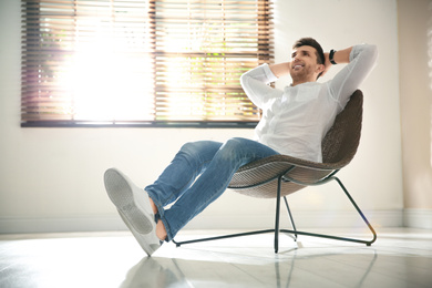 Photo of Young man relaxing near window at home. Space for text