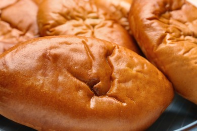 Photo of Many delicious baked patties on plate, closeup