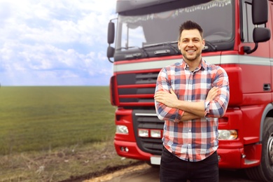 Photo of Portrait of driver at modern truck outdoors. Space for text