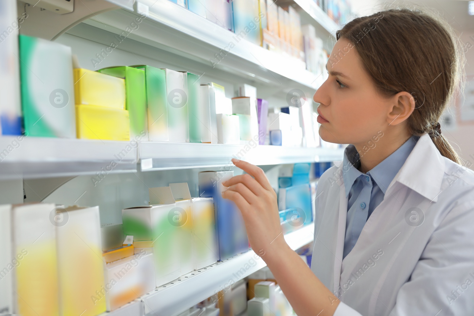 Photo of Professional pharmacist near shelves in modern drugstore