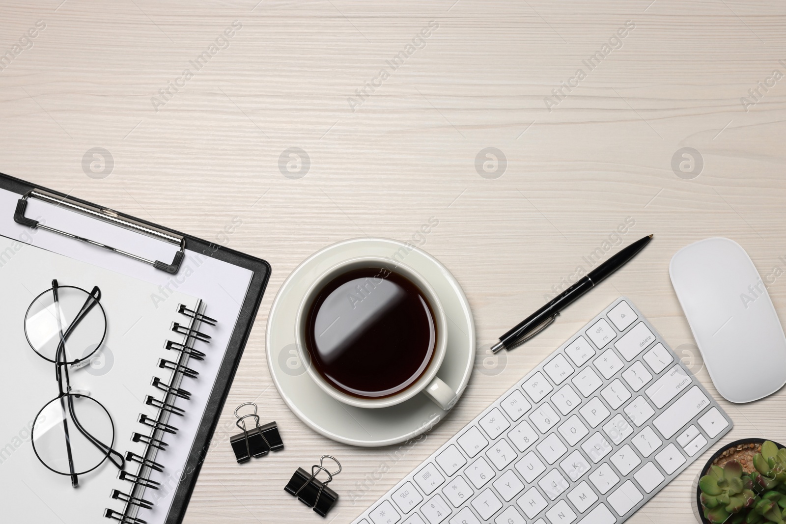 Photo of Home office. Coffee, glasses, houseplant, stationery, computer keyboard and mouse on white wooden desk, flat lay. Space for text