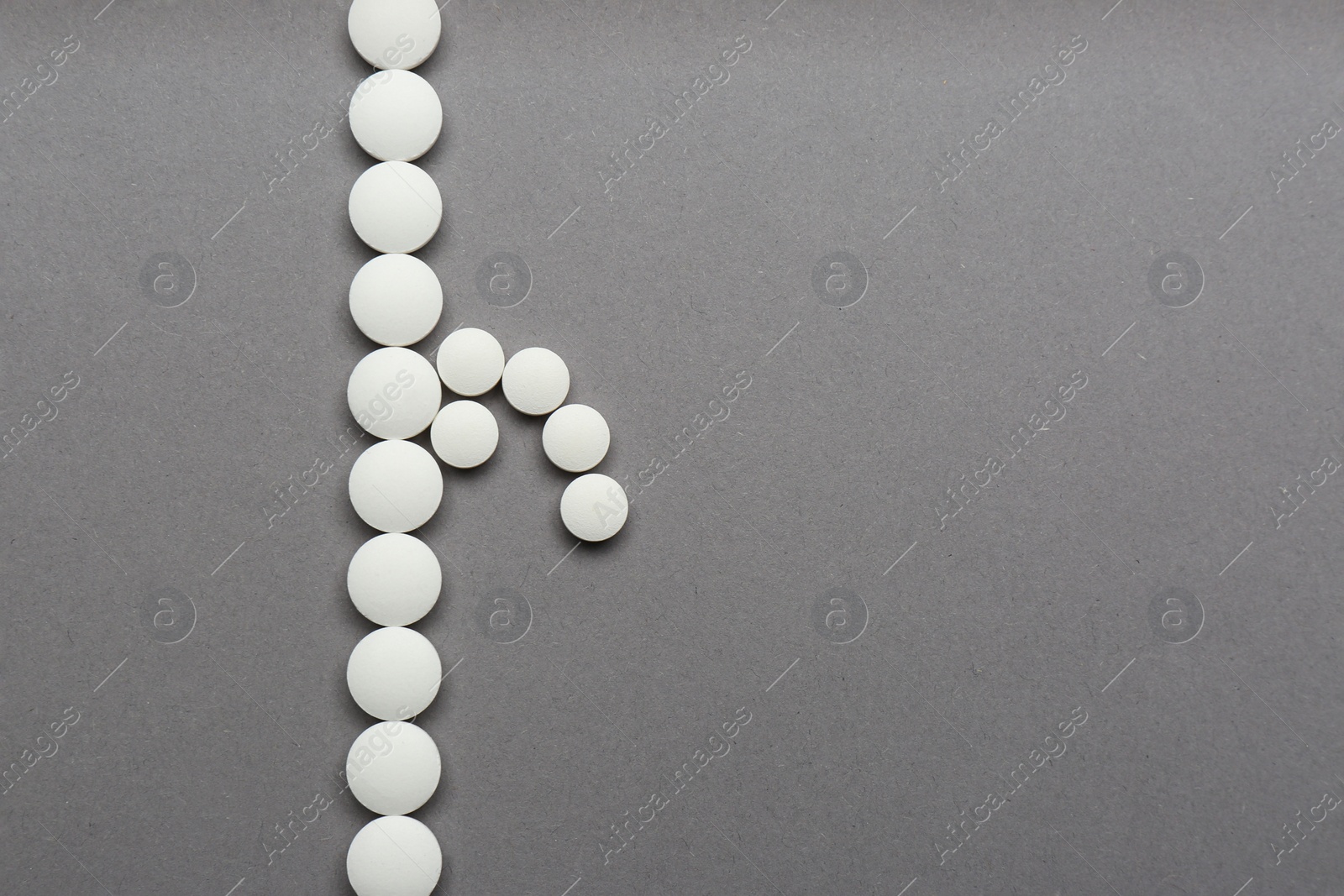 Photo of Composition of white pills symbolizing potency problems on grey background, flat lay. Space for text