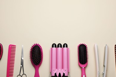 Photo of Flat lay composition of professional hairdresser tools on beige table, space for text