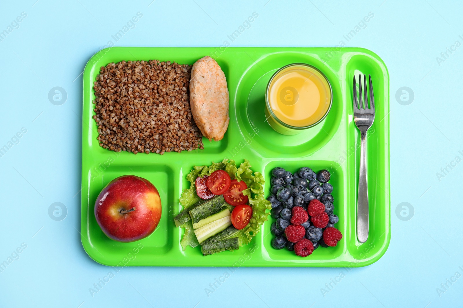 Photo of Serving tray with healthy food on light blue background, top view. School lunch