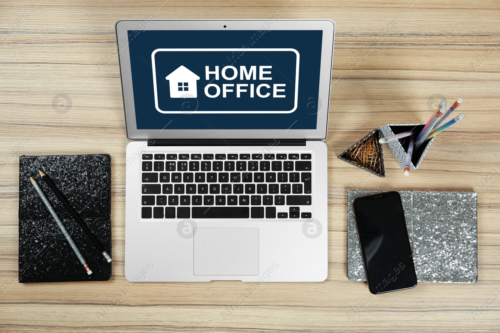 Image of Modern laptop with text HOME OFFICE on wooden table, flat lay