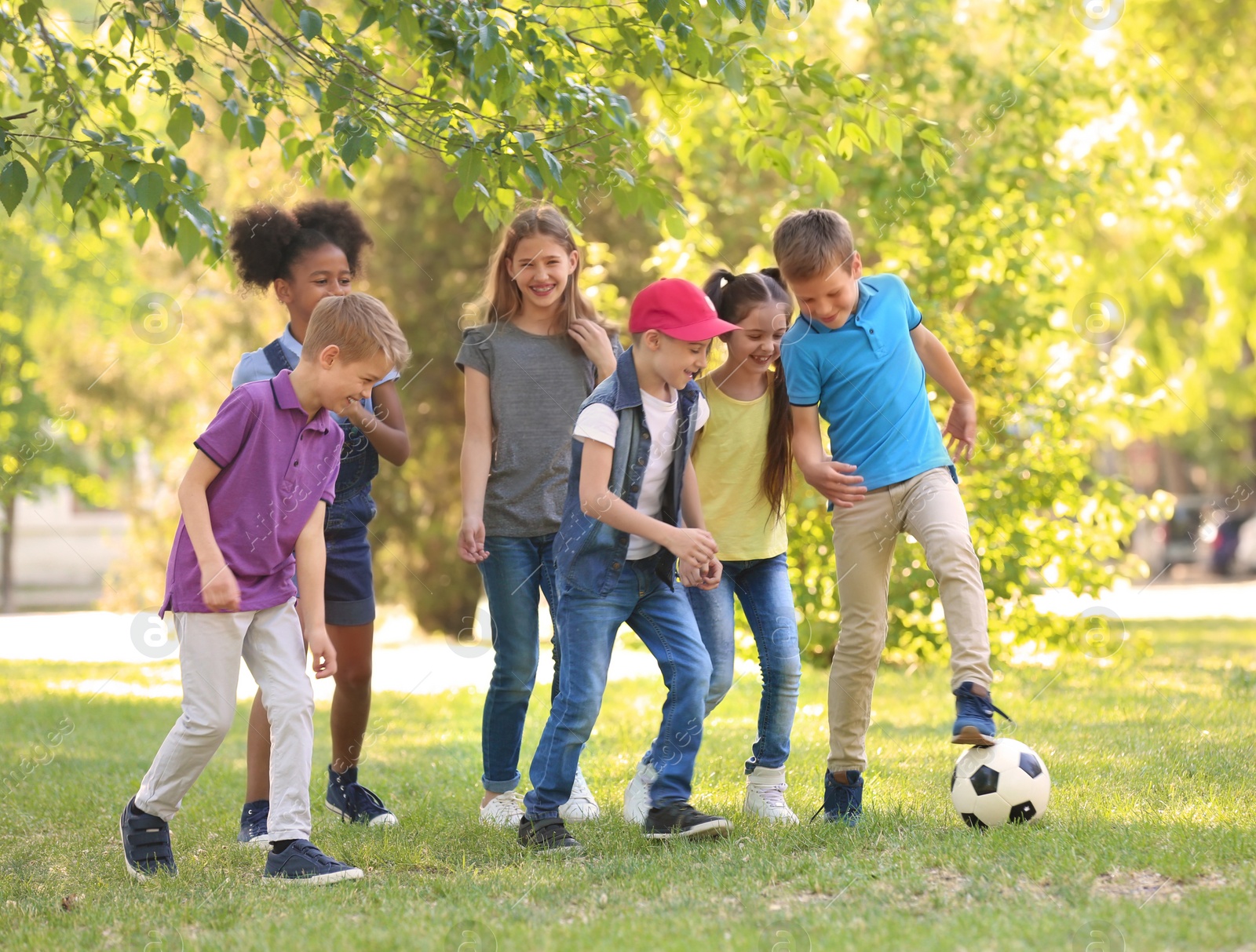 Photo of Cute little children playing with ball outdoors on sunny day