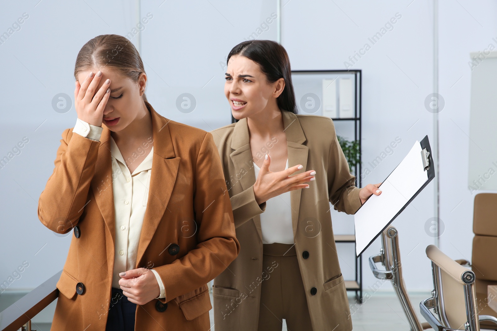 Photo of Boss screaming at employee in office. Toxic work environment