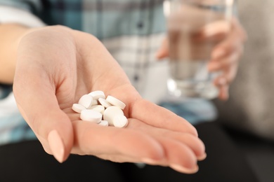 Photo of Woman holding pills in hand, closeup view