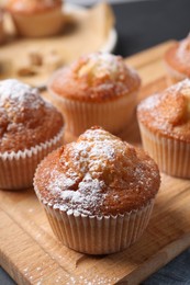 Photo of Delicious sweet muffins on wooden board, closeup