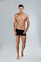 Handsome man in black underwear on light grey background