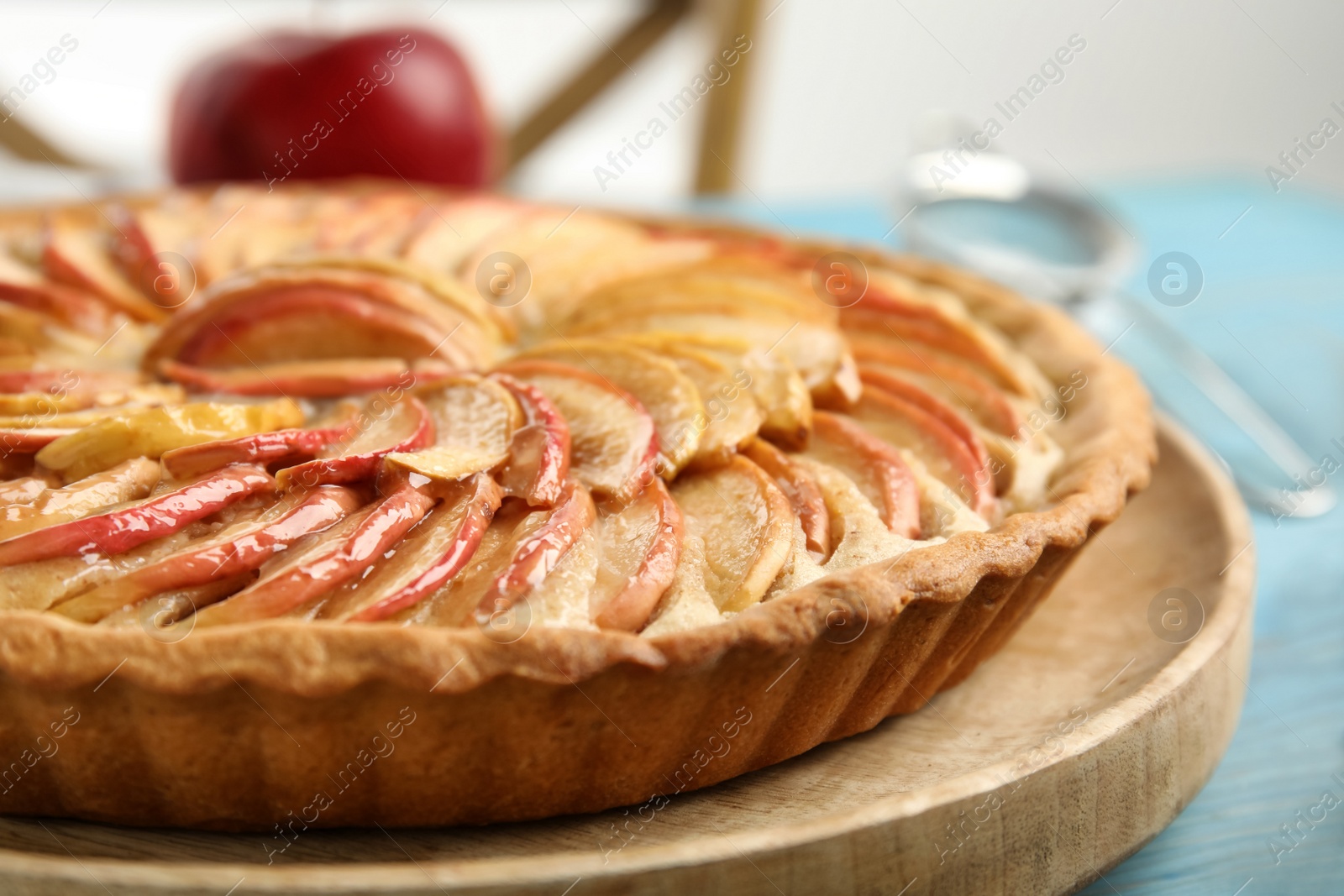 Photo of Delicious homemade apple tart on light blue wooden table, closeup