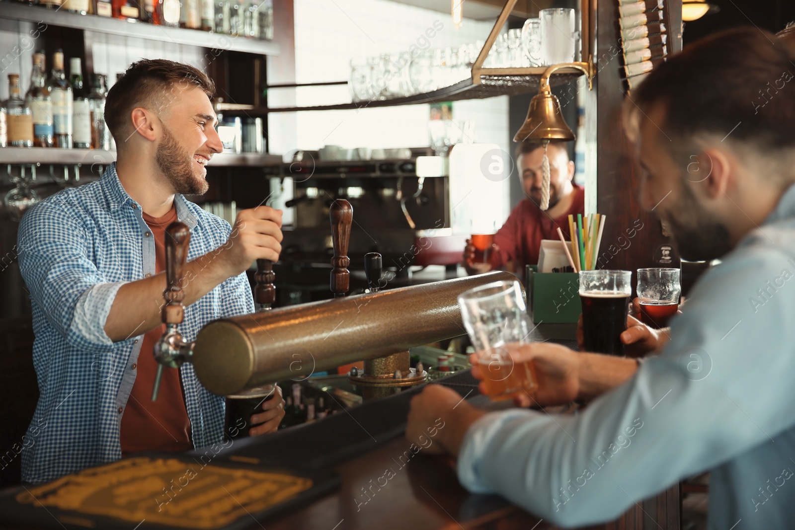 Photo of Bartender working at beer tap in pub