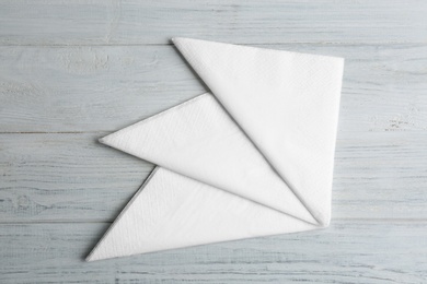 Photo of Clean napkins on white wooden table, flat lay