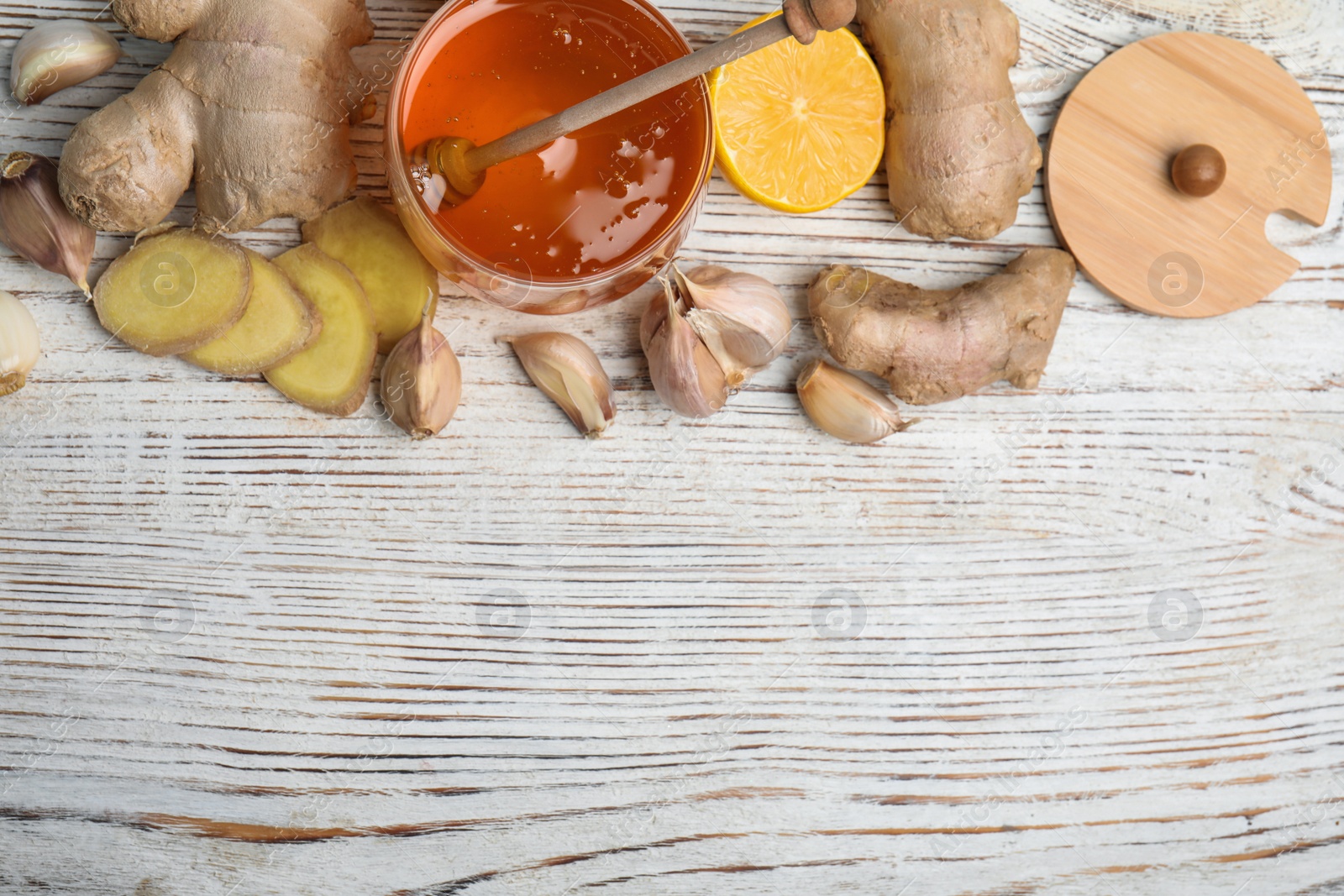 Photo of Fresh garlic and other natural cold remedies on white wooden table, flat lay. Space for text