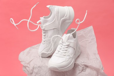 Photo of Stylish presentationtrendy sneakers on pink background