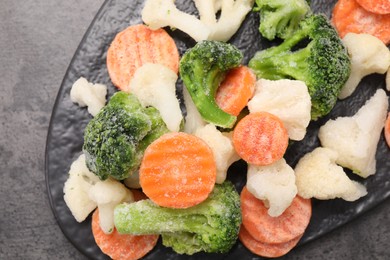 Photo of Mix of different frozen vegetables on grey table, top view