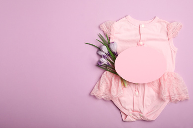 Photo of Child's clothes, flowers and card with space for text on pink background, flat lay