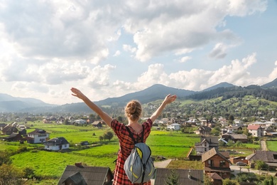 Young woman enjoying beautiful view of village in mountains