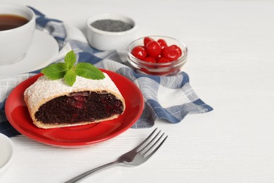 Delicious strudel with cherries and poppy seeds on white wooden table. Space for text