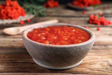 Delicious rowan jam in bowl on wooden table, closeup