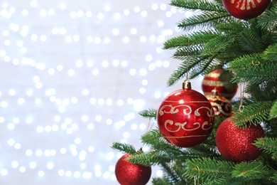 Photo of Christmas tree with festive decor against blurred fairy lights