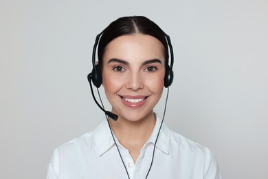Hotline operator with modern headset on light grey background. Customer support