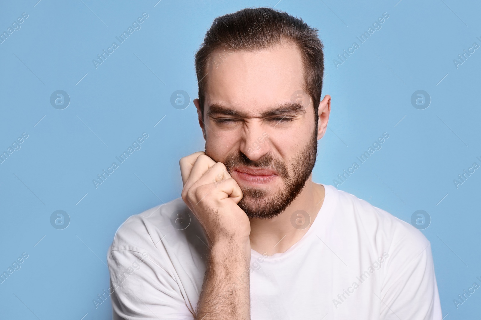 Photo of Young man suffering from toothache on grey background