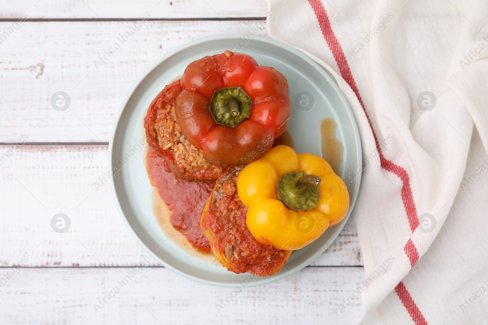 Photo of Delicious stuffed bell peppers on white wooden table, flat lay