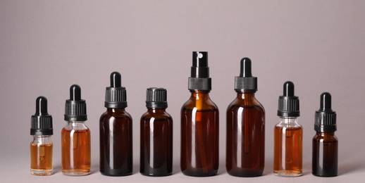 Photo of Cosmetic bottles of essential oils on color background