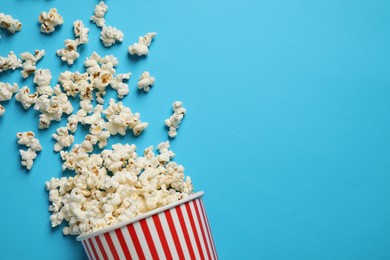Photo of Delicious popcorn on light blue background, top view. Space for text