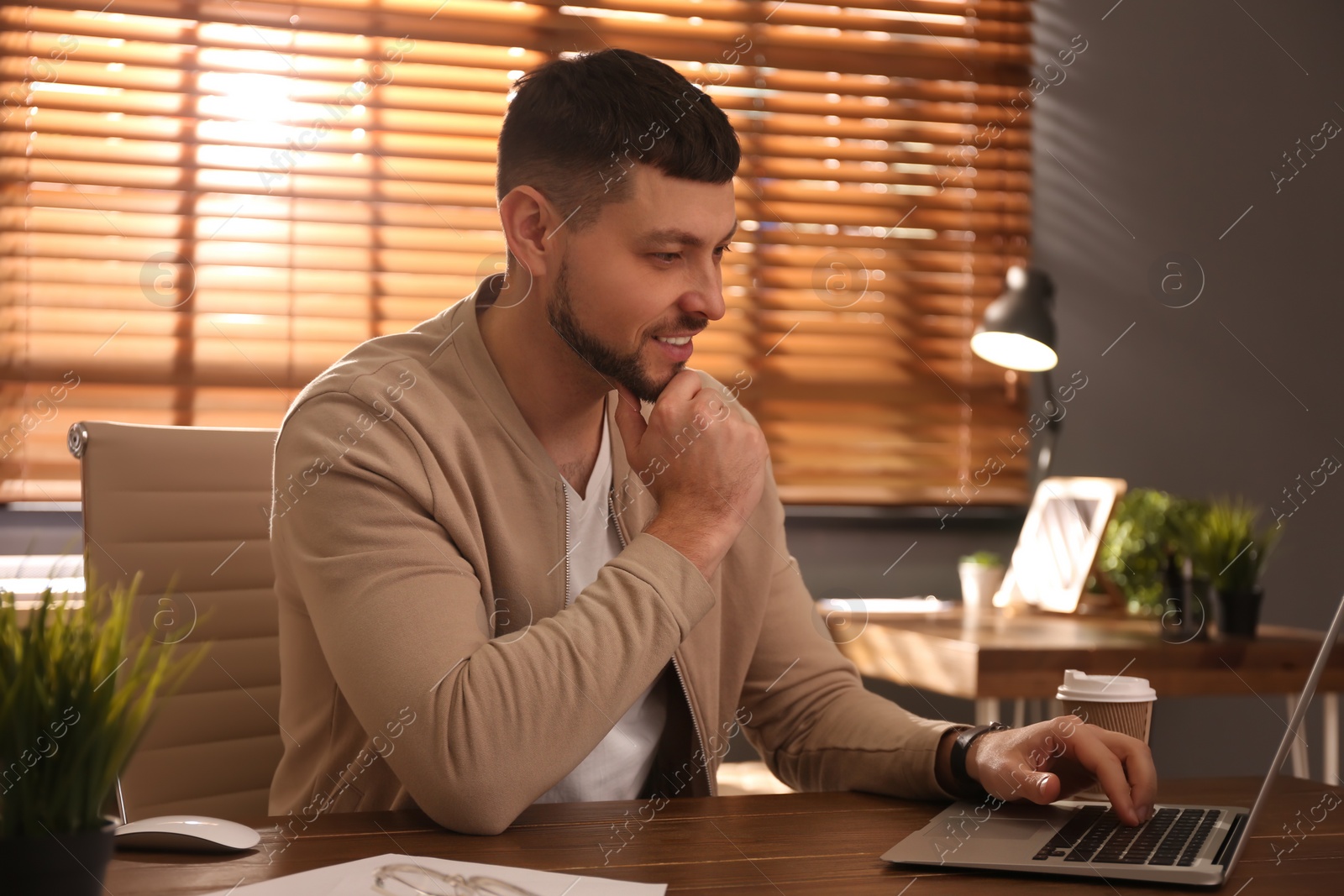 Photo of Freelancer working on laptop at table indoors