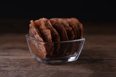 Photo of Glass bowl with used tea bags on wooden table