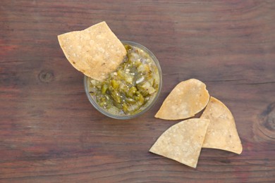 Tasty salsa sauce and tortilla chips on wooden table, flat lay