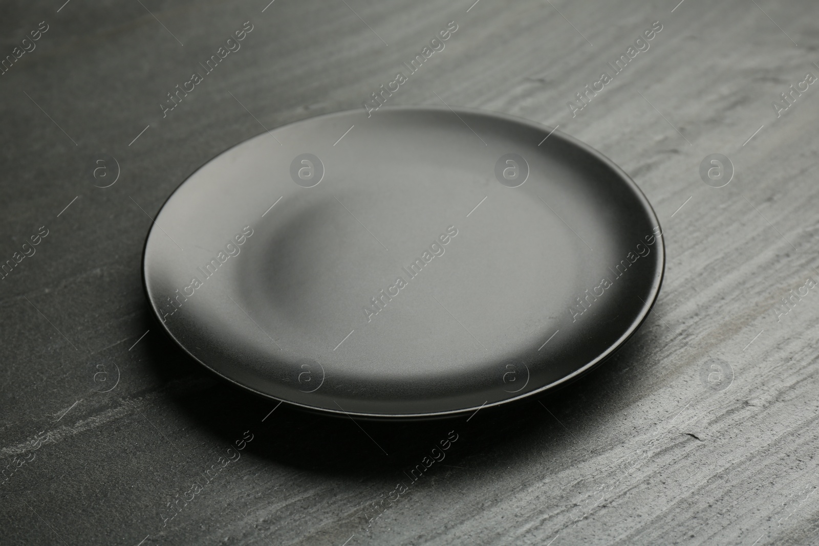 Photo of Beautiful ceramic plate on black table, closeup