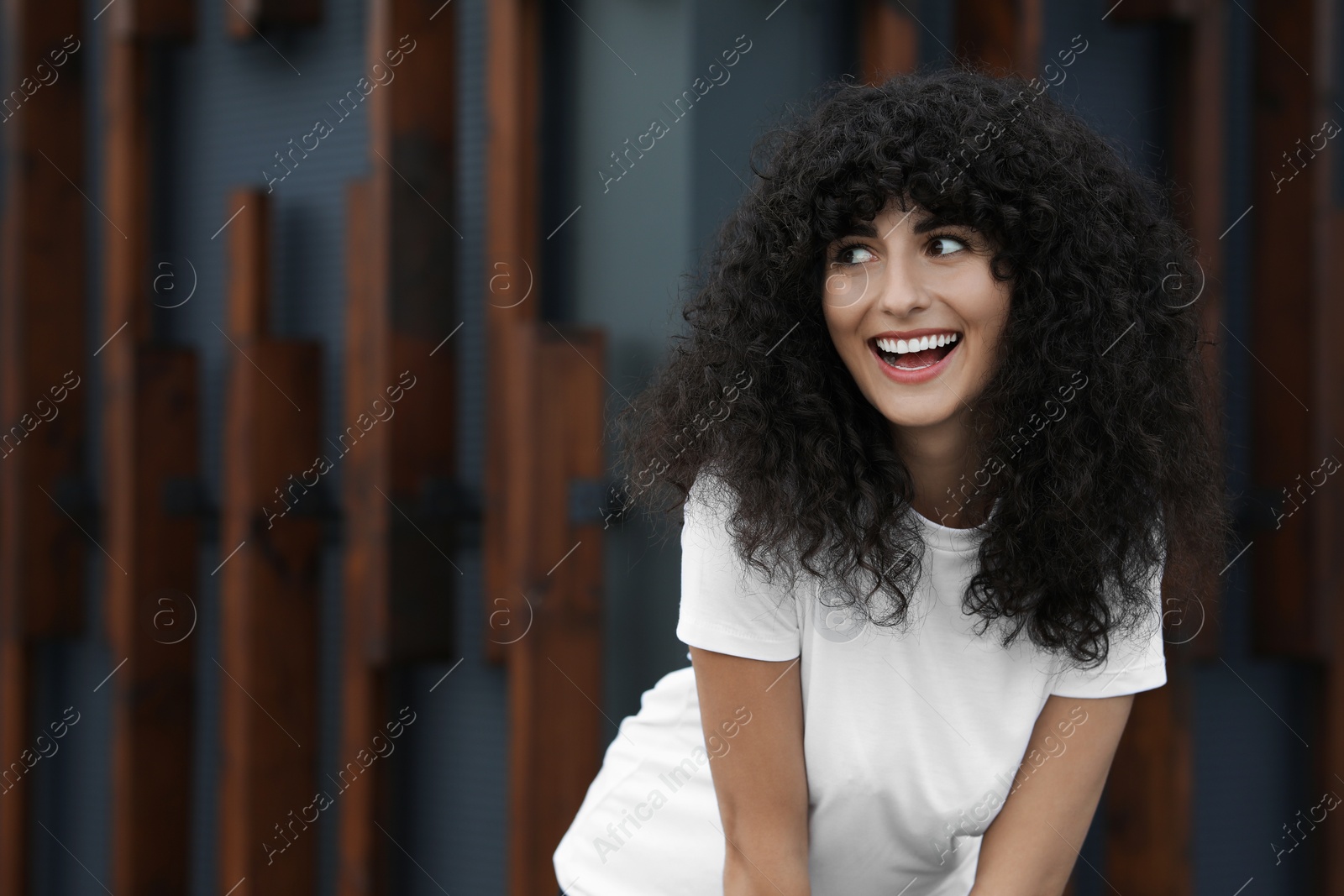 Photo of Portrait of beautiful woman near building. Attractive lady smiling and posing for camera. Space for text