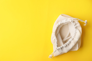 Photo of Cotton eco bag on yellow background, top view. Space for text