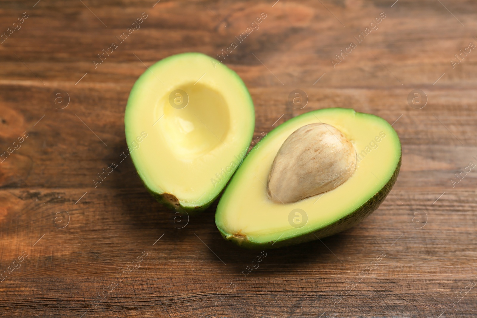 Photo of Tasty ripe green avocado on wooden background