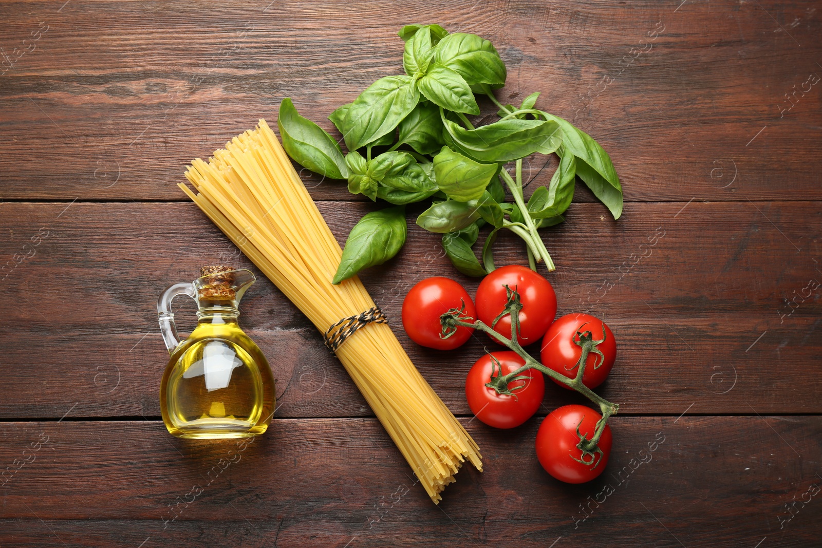 Photo of Raw pasta, spices and products on wooden table, flat lay