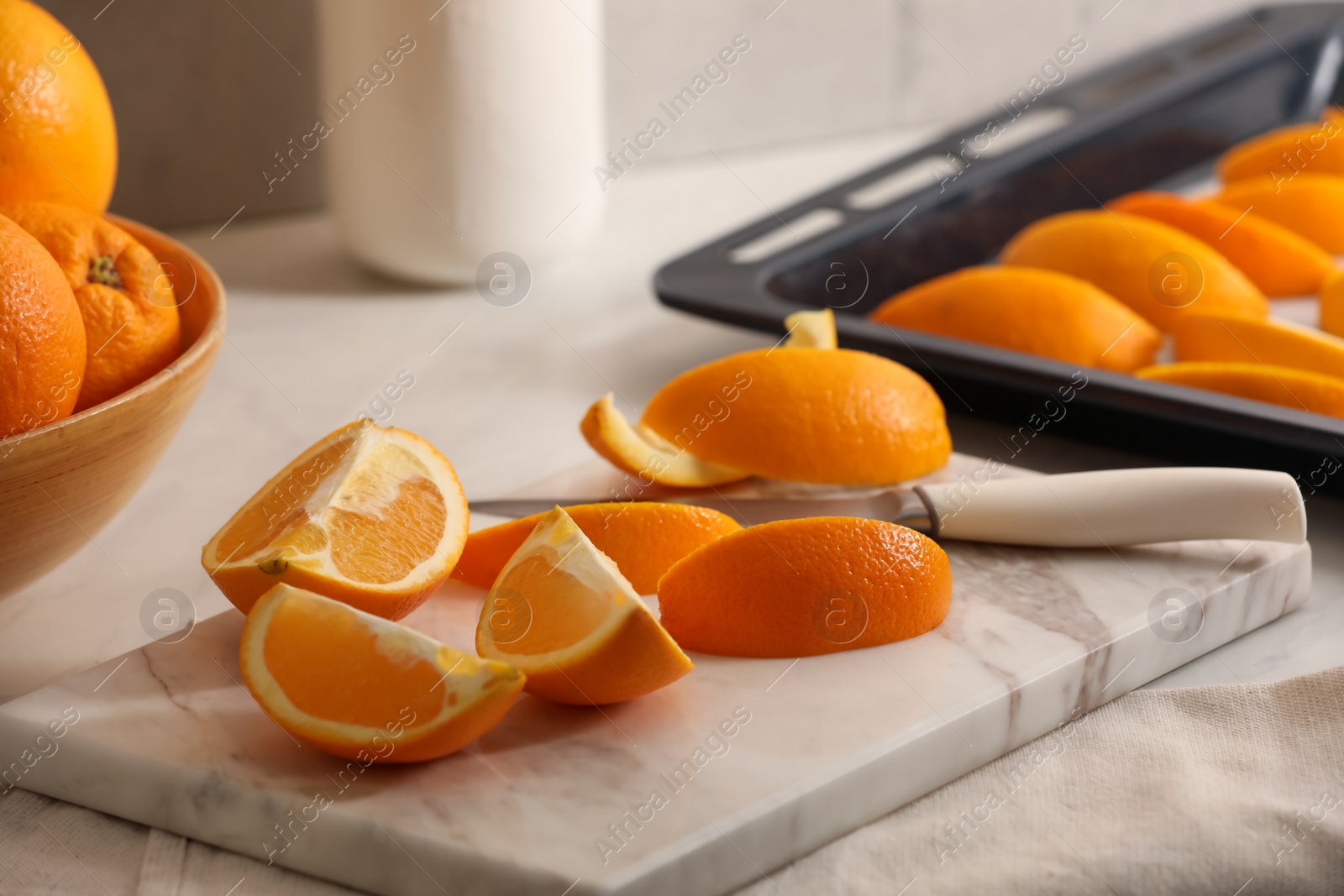 Photo of Fresh orange peels and juicy fruits on white table