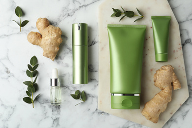 Photo of Set of cosmetic products, ginger and plants on white marble table, flat lay