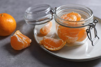 Photo of Fresh ripe tangerines on light grey table, closeup