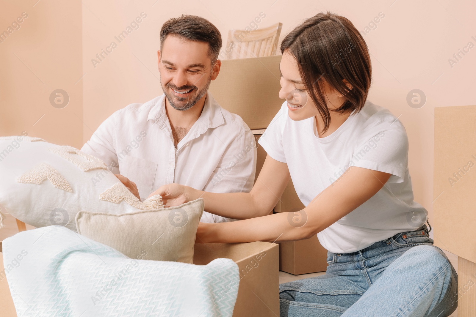 Photo of Happy couple unpacking box in new apartment. Moving day