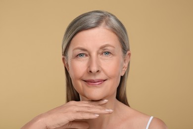 Photo of Portrait of senior woman with aging skin on beige background. Rejuvenation treatment