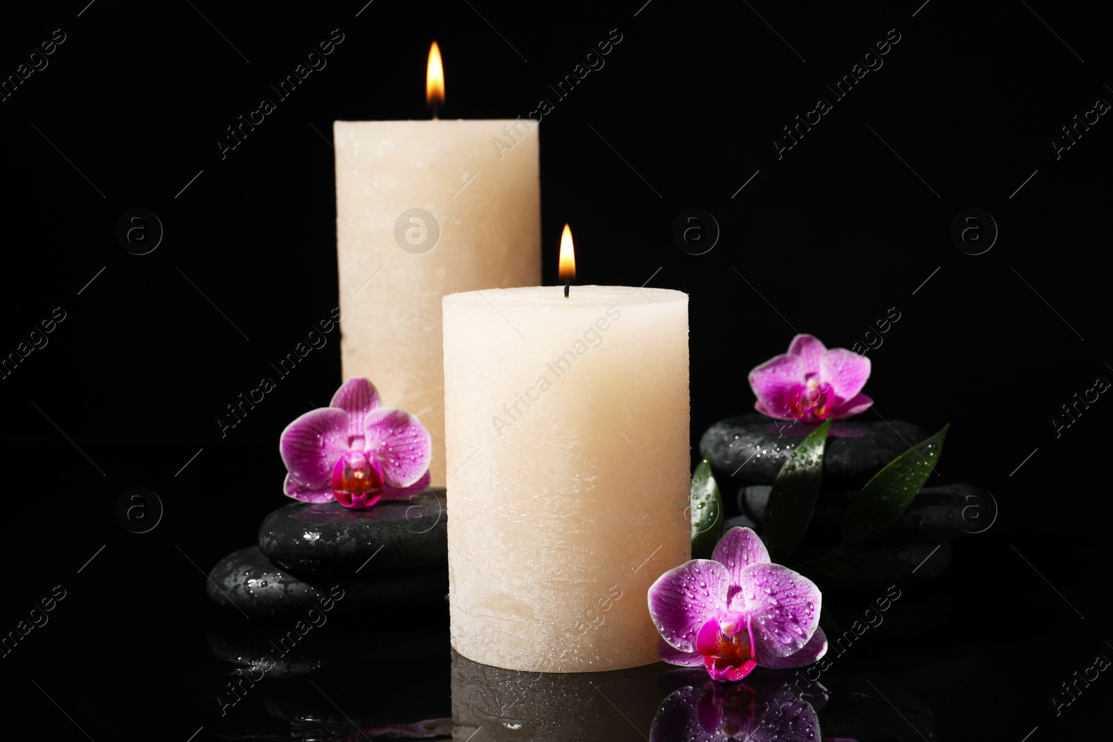 Photo of Composition with candles and spa stones on black background