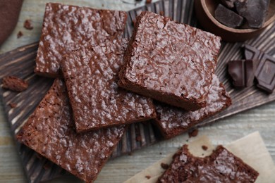 Delicious chocolate brownies on wooden table, flat lay