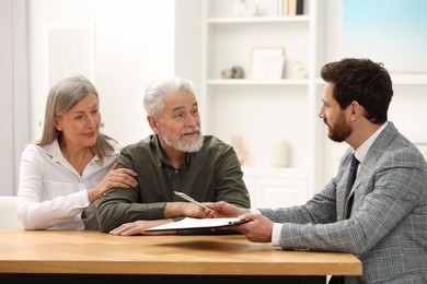 Notary consulting senior couple about Last Will and Testament in office