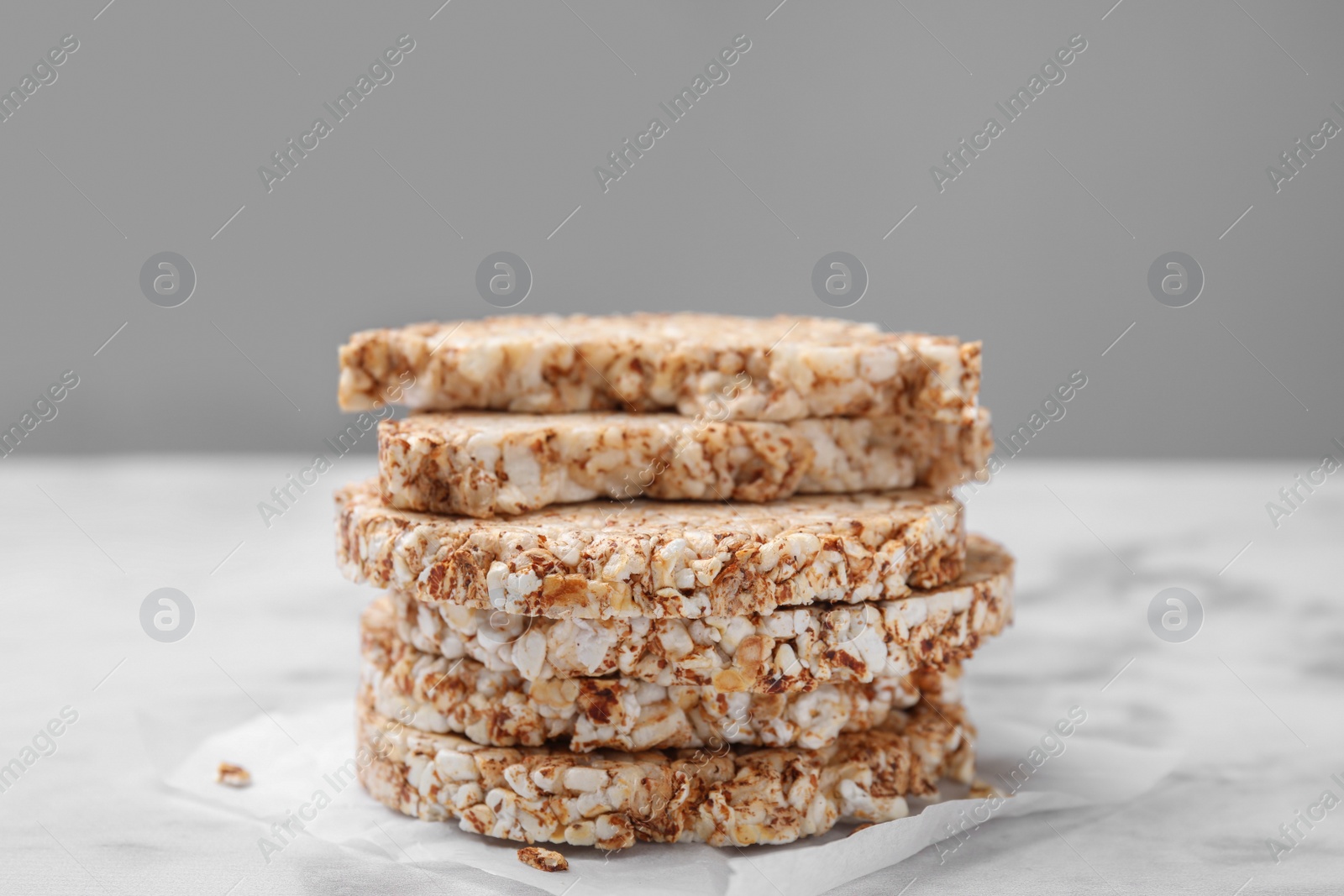 Photo of Stack of crunchy buckwheat cakes on white marble table, closeup